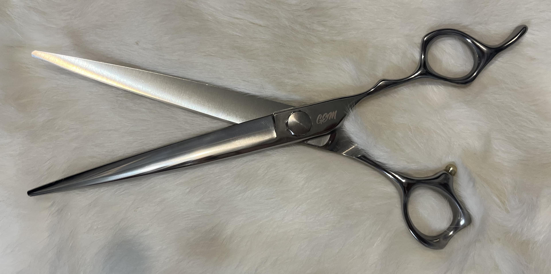 Silver hairdressing scissors on white fur
