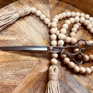 Silver hairdressing scissors on wooden bead garland