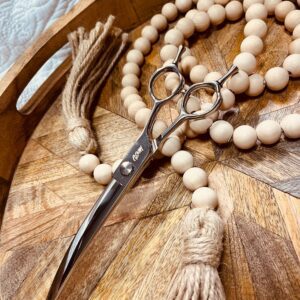 Curved hairdressing scissors with wooden bead garland