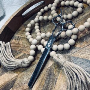 Silver hair thinning scissors on wooden tray
