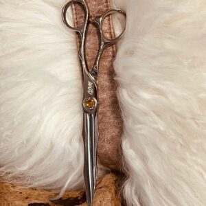 Polished silver hairdressing scissors on white fur