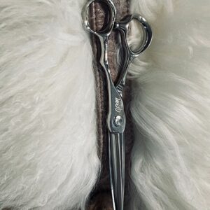 Silver hairdressing scissors on white fur