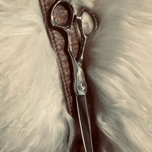 Silver hairdressing scissors on leather and fur
