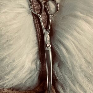 Silver hairdressing scissors on white fur
