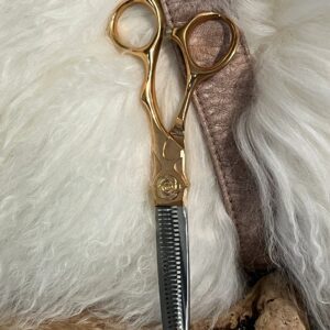 Gold thinning shears on white fur background