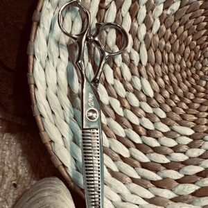 Silver hair thinning scissors on woven basket